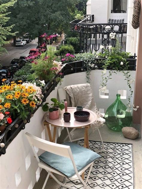 The Balcony Is Filled With Potted Plants And Flowers