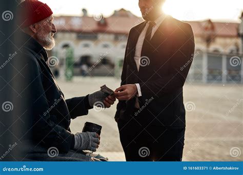 Un Homme D Affaires Donne De L Argent Aux Pauvres Mendiants Image Stock