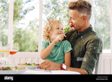 Cute Curly Blonde Haired Son Giving Tomato To His Father Stock Photo Alamy