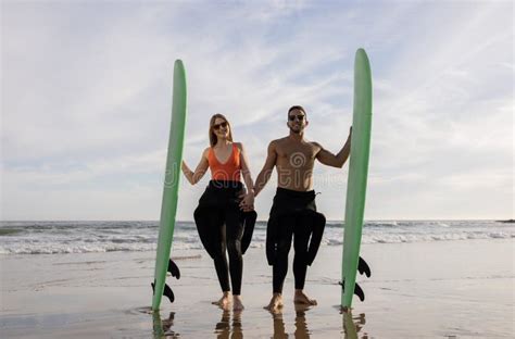 Romantic Young Surfers Couple Posing Together On The Beach In Summer