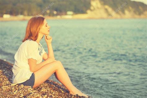 Triste Chica Sentada En La Playa Y Mira A La Distancia En El Mar