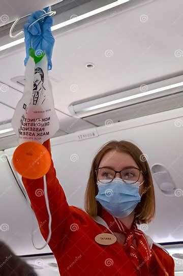 Flight Attendant Demonstrates How To Use An Oxygen Mask In An Emergency