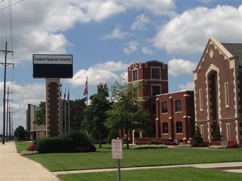 A Street Sign In Front Of A Brick Building And Flag Pole With An