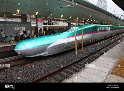 TOKYO, JAPAN - MAY 4, 2012: Travelers board Shinkansen Hayabusa train at Tokyo Station. Hayabusa ...