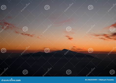 Colorful Sunset Over Mountain Peak Silhouette Surrounded By Low