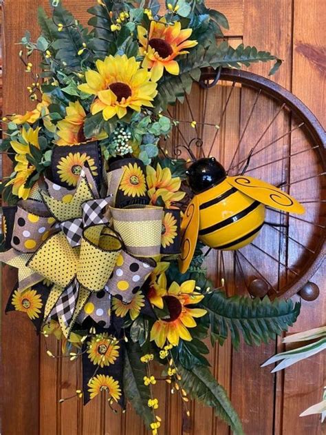 A Yellow And Black Sunflower Wreath With A Bee On It Next To A Wheel