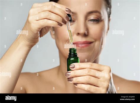 Beautiful Middle Aged Woman Holding Bottle With Cosmetic Oil Or Serum