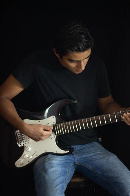 Premium Photo | Boy playing electric guitar inside a studio