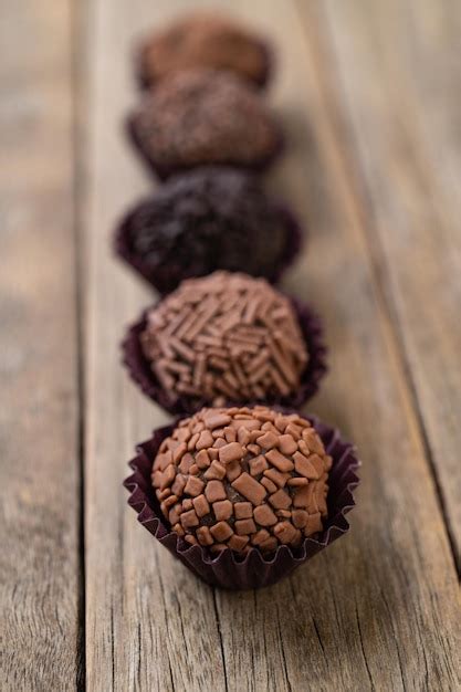 Típicos brigadeiros de chocolate brasileiros sobre mesa de madeira