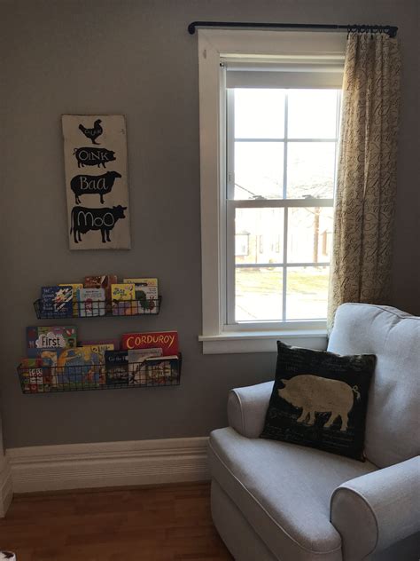 A White Chair Sitting In Front Of A Window Next To A Book Shelf Filled