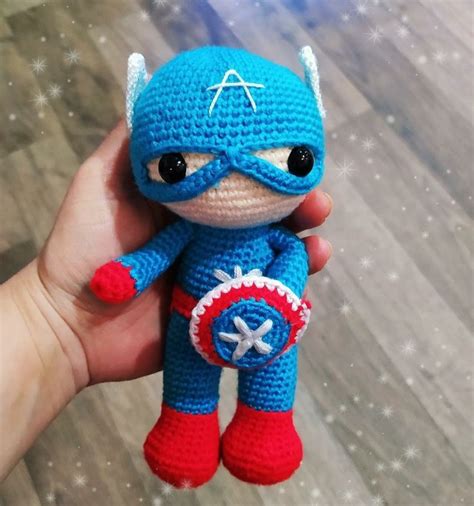 A Small Crocheted Toy Is Being Held In Someone S Hand