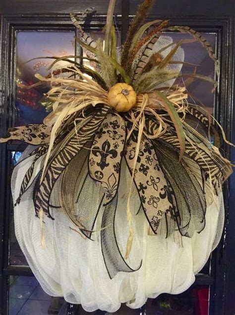 A White Pumpkin Decorated With Black And Gold Decorations On Top Of A