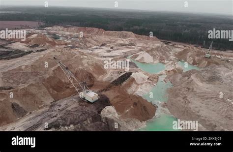 Deep Huge Mining Quarry With Huge Mounds Of Minerals Excavator Works