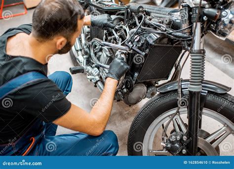 Worker Repairing Motorcycle Engine At The Workshop Stock Photo Image