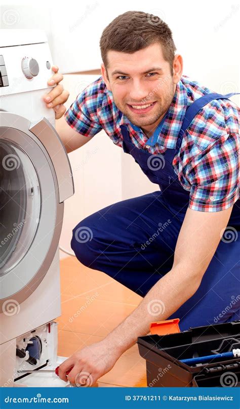 Handyman In Blue Uniform Fixing A Washing Machine Stock Image Image