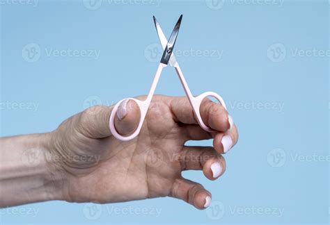 Female Hand Holding Scissors Isolated On Blue Background 15275835 Stock