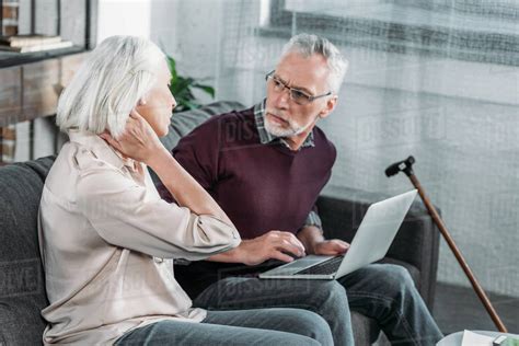 Side View Of Senior Woman Suffering From Strong Neck Ache Stock Photo