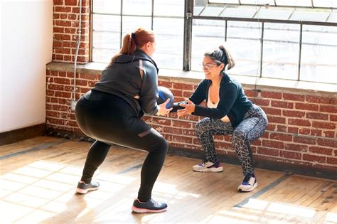 Mujeres Haciendo Sentadillas En Clase De Gimnasia Foto Premium