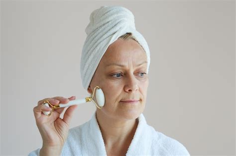 Belle femme mature en peignoir avec une serviette blanche sur la tête