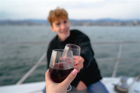 Premium Photo Young People Clink Glasses Of Wine On A Yacht In The Sea