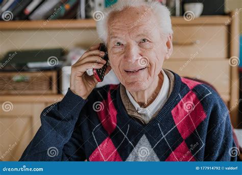 Elderly Man Talking On Phone Sitting At Home Stock Photo Image Of