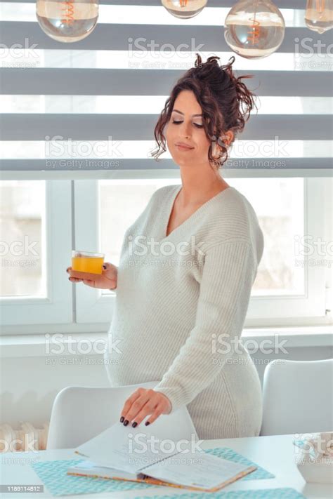 Pregnant Woman At Home Middleaged Pregnant Woman Reading Book And