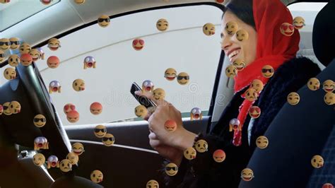 Animation Of Od Falling Emojis Over Woman In Hijab Using Smartphone