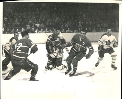 An Old Black And White Photo Of Men Playing Ice Hockey In Front Of A Crowd