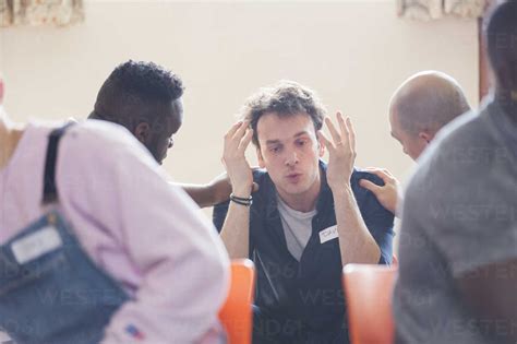 Men Comforting Man Talking In Group Therapy Stock Photo