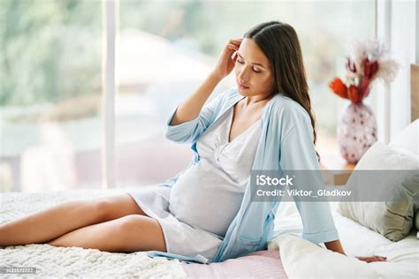 Portrait Of Young Beautiful Pregnant Woman Posing At Home Siiting In