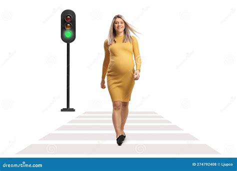 Full Length Portrait Of A Pregnant Woman In A Yellow Dress Crossing A