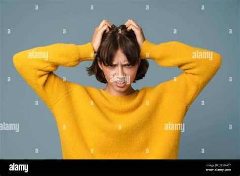 Portrait Of A Frustrated Angry Woman Screaming Out Loud And Pulling Her