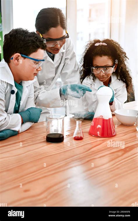 Children Science Teacher And Experiment With Beaker For Learning