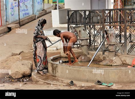 Indian Mother Washing Her Son In An Village Fountain Orchha Madhya