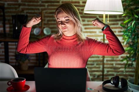 Blonde Woman Using Laptop At Night At Home Showing Arms Muscles Smiling
