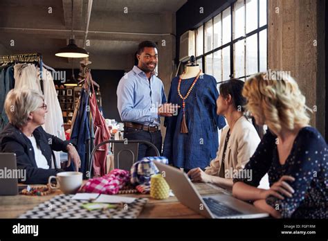 Four Fashion Designers In Meeting Discussing Garment Stock Photo Alamy