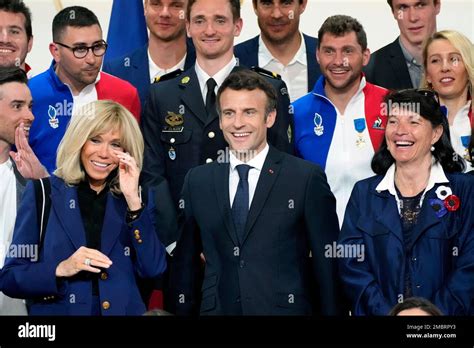 French President Emmanuel Macron Center And His Wife Brigitte Macron Left Pose With Some Of