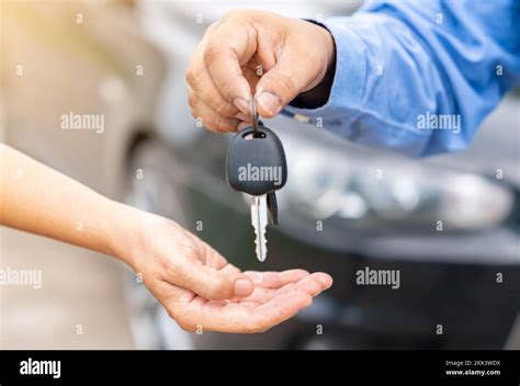 Close Up Car Salesman Handing Keys To Customer When Finish Leasing On