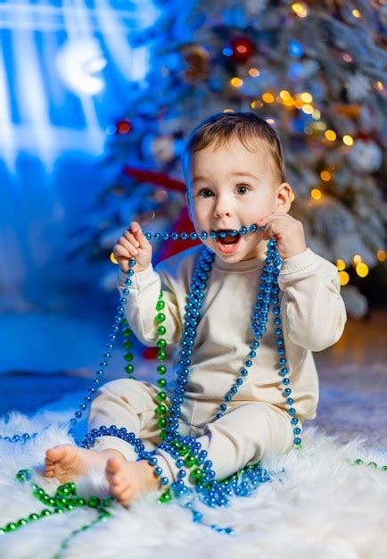 Niño pequeño feliz jugando cerca del árbol de navidad feliz navidad y