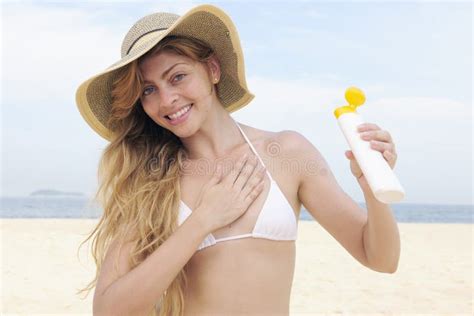 Mujer Que Aplica La Loci N Del Bronceado En La Playa Imagen De Archivo