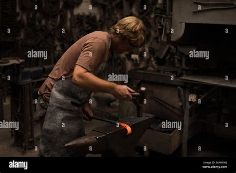 Blacksmith Hammering A Hot Metal Rod Stock Photo Alamy