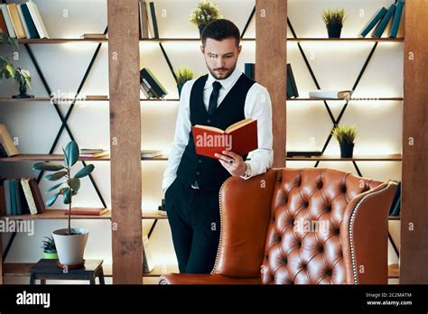 Handsome Young Man In Elegant Suit Reading A Book In Modern Luxury