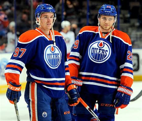 two edmonton oilers hockey players standing next to each other