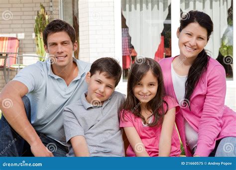 Familia De Cuatro Miembros Que Se Sienta Junto Al Aire Libre Imagen