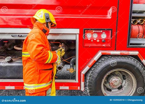 Firefighter Holding Water Hose Near the Truck with Equipment Stock Photo - Image of hose, help ...