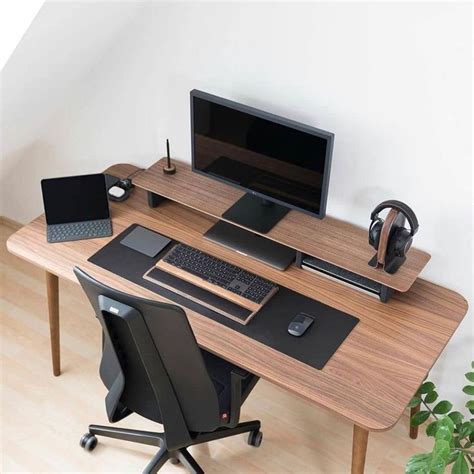 A Computer Desk With A Monitor Keyboard And Headphones On It Next To A