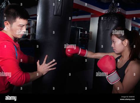 Boxing Couch Holding The Punching Bag And Training A Female Student