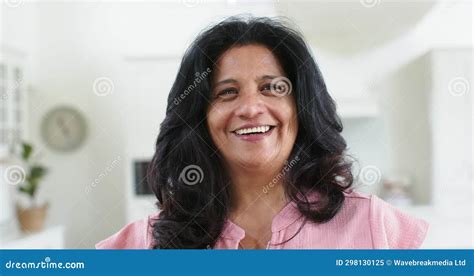 Happy Biracial Senior Woman Standing And Laughing In Sunny Room At Home