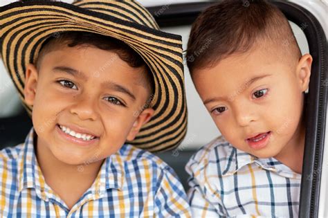 Retrato De Dos Niños Hermanos Colombianos Felices Y Tiernos Sonriendo Y