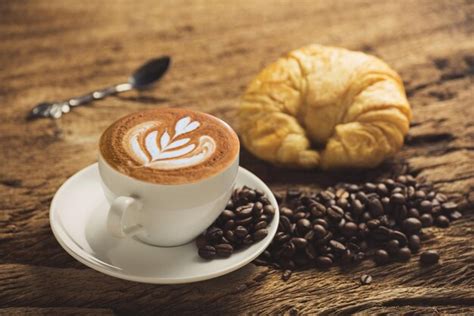 Premium Photo Close Up Of Coffee With Roasted Beans And Croissant On